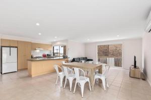 a kitchen and dining room with a table and chairs at Beautiful 3 bedroom house with Corio Bay view at heart of Clifton Springs in Clifton Springs