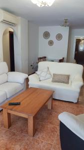 Sala de estar con sofá blanco y mesa de centro en APARTAMENTO PLAYA AZUL, en Rincón de la Victoria