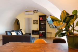 a living room with a couch and a table with a plant at Casa Anastasia with private patio by GardaDoma in Brenzone sul Garda +4 photos