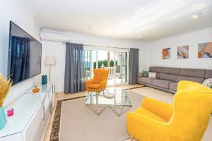 een woonkamer met gele stoelen en een bank bij Villa Santo Sol by Villa Plus in Santa Fe de los Boliches