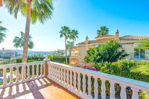 een huis met palmbomen en een witte leuning bij Villa Santo Sol by Villa Plus in Santa Fe de los Boliches