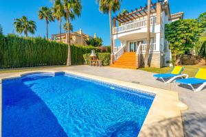 een zwembad met twee stoelen en een huis bij Villa Santo Sol by Villa Plus in Santa Fe de los Boliches