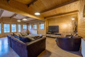 a living room with two couches and a flat screen tv at Cabin in the countryside in Sible Hedingham