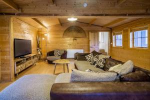 a living room with couches and a flat screen tv at Cabin in the countryside in Sible Hedingham