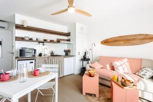 a living room with a couch and a table at Les Pins, studio vue mer in Rivedoux-Plage
