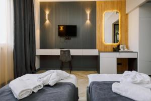 a hotel room with two beds and a mirror at Bel Mare Boutique Hotel in Batumi
