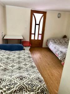 Zimmer mit 2 Betten, einem Tisch und einer Tür in der Unterkunft Квартира in Czernowitz