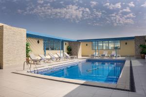 una grande piscina con sedie e una piscina di Plaza Inn Doha a Doha