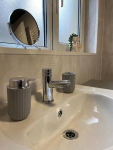 a white bathroom sink with a mirror and a mirror at Neat Retreat-Cilfynyd-Pontypridd in Pontypridd