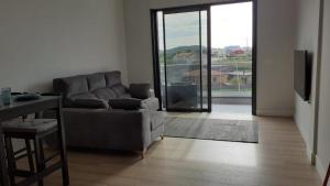 - un salon avec un canapé et une porte coulissante en verre dans l'établissement Apartamentos Marina Cordelia 1D, à O Grove