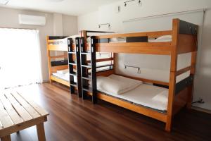 two bunk beds in a room with a wooden floor at Ise Guest House Sora in Ise