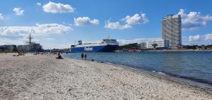 uma praia com um navio de cruzeiro na água em Ferienhaus Freibeuterweg 13 - b51130 em Lübeck