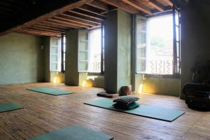 Habitación con 4 esterillas de yoga en el suelo de madera en Romy's Room - ensuite in shared Village Chateau, en Chalabre