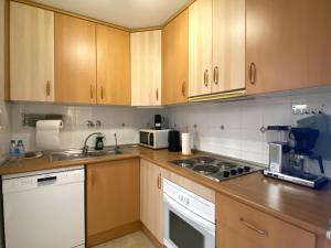 a kitchen with wooden cabinets and a stove top oven at Precioso duplex en Torrevieja in Torrevieja