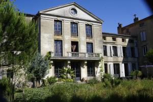 un edificio antiguo con balcón en la parte delantera en Romy's Room - ensuite in shared Village Chateau, en Chalabre