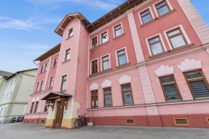 a pink building with windows on a street at FarawayHomes Studio Sankt Michael #5 in Liesingthal