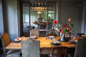 una mesa de madera con flores en el comedor en Romy's Room - ensuite in shared Village Chateau, en Chalabre
