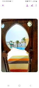 um espelho com um reflexo de uma praia e palmeiras em Maison Leila chambres d hotes em Midoun