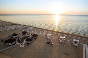 a beach with tables and chairs and the ocean at Coral Residence in Mamaia