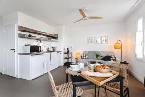 cocina y comedor con mesa y sillas en Le Phare, Studio vue mer, en Rivedoux-Plage