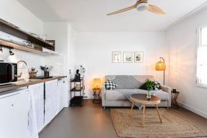 Sala de estar blanca con sofá y mesa en Le Phare, Studio vue mer, en Rivedoux-Plage