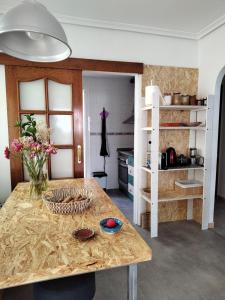 eine Küche mit einem Tisch mit Blumen darauf in der Unterkunft Vera Playa Apartamento muy cuco con jardín y 2 habitaciones in Vera