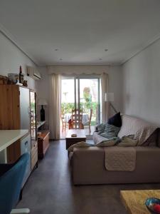 ein Wohnzimmer mit einem Sofa und einem Tisch in der Unterkunft Vera Playa Apartamento muy cuco con jardín y 2 habitaciones in Vera