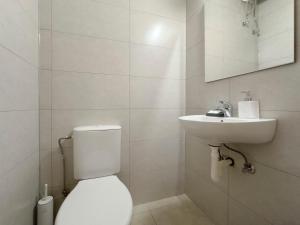 a white bathroom with a toilet and a sink at Glenvar Heights I1 90 sqm apt in Paleo Faliro in Athens