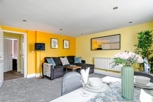 ein Wohnzimmer mit gelben Wänden und einem Sofa in der Unterkunft Brighton Lanes Cosy One Bedroom Apartment in Brighton & Hove