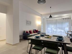 a dining room and living room with a table and chairs at Glenvar Heights I1 90 sqm apt in Paleo Faliro in Athens