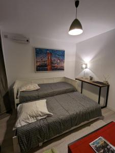 a bedroom with two beds and a table with a lamp at Appartement paisible in Clichy