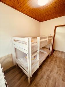 a room with two bunk beds and a wooden ceiling at 1 - Gemütlicher Bungalow am Fuße der Wasserkuppe in Dipperz