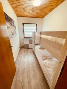 a room with two bunk beds and a window at Gemütlicher Bungalow am Fuße der Wasserkuppe in Dipperz