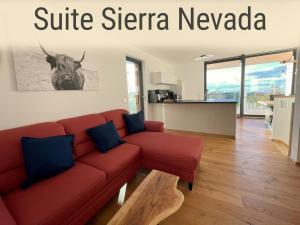 a living room with a red couch and a cow on the wall at Eichen-Chalet in Eichenberg