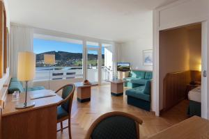 un soggiorno con divano e scrivania e una camera di Sauerland Stern Hotel a Willingen