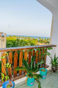 einen Balkon mit Topfpflanzen und Meerblick in der Unterkunft Casa bella Beach apartment in Ukunda