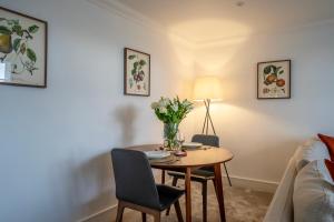 a dining room table with a vase of flowers on it at Apartment 8 - Bootham House in York