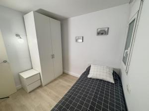 een kamer met een bed in de hoek van een kamer bij Apartamento Marina Roses in Roses