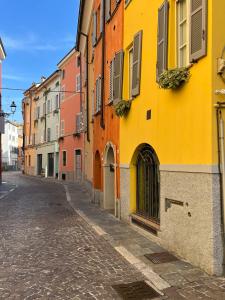 an empty street in a city with colorful buildings at XX Settembre Studio Apartment in Parma
