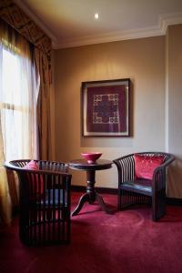 a room with two chairs and a table and a table and chairs at Tayfin Royale Hotel & Conference Centre in Centurion