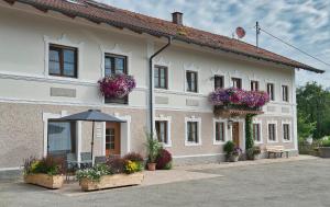 un gran edificio blanco con flores en las ventanas en Gästehof Huber, en Forstern