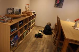 un niño pequeño sentado en el suelo en una habitación en Gästehof Huber, en Forstern