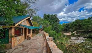 un edificio con una pasarela junto a un río en Dan Maasai Mara safari camp en Sekenani