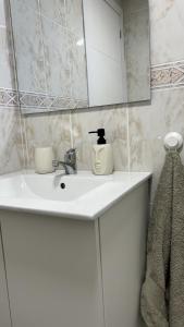 uma casa de banho com um lavatório branco e um espelho. em Piso Universidad Alicante em San Vicente del Raspeig