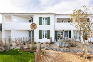 uma casa branca com uma cerca na frente em La Dune, appart familial vue mer em Rivedoux-Plage
