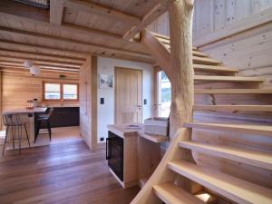 una escalera en una cabaña de madera con cocina y mesa en Chalet d'Anselme, en Cordon