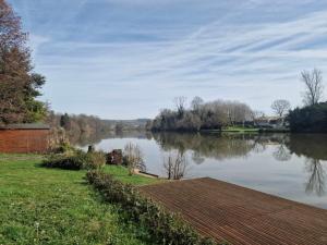 - une vue sur une rivière avec un quai en bois dans l'établissement Riverside Gîte Pinel Hauterive, à Pinel-Hauterive