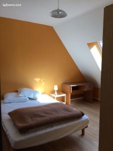 ein Schlafzimmer mit einem Bett und einem Schreibtisch im Dachgeschoss in der Unterkunft Longère 200 m2 in Noyal-Muzillac