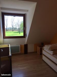 ein Zimmer mit einem Fenster und einem Bett darin in der Unterkunft Longère 200 m2 in Noyal-Muzillac