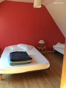 ein Schlafzimmer mit einem Bett mit einer roten Wand in der Unterkunft Longère 200 m2 in Noyal-Muzillac